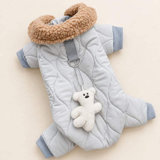 Light grey quilted four-leg dog jacket laid flat with tan fluffy collar, ring and teddy charm