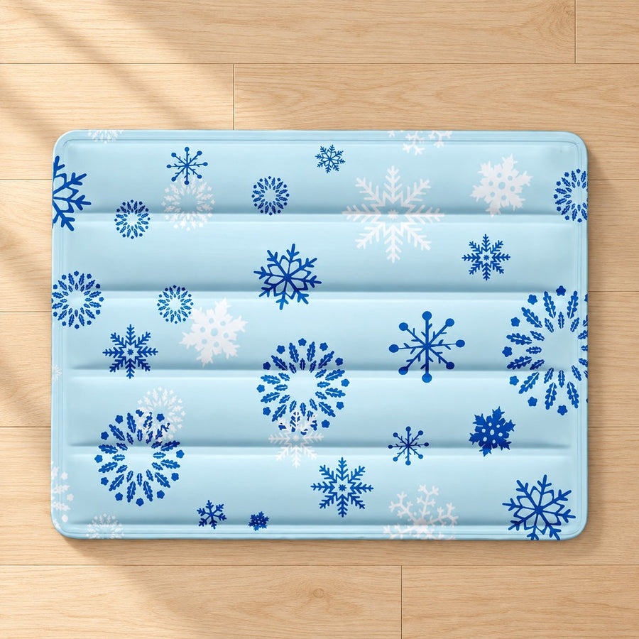 Light blue pet mat with blue and white snowflake print, rounded corners and horizontal quilted channels