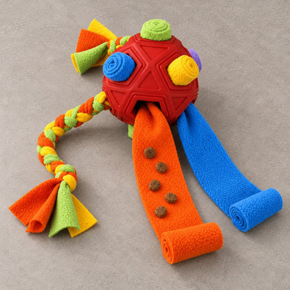 Red snuffle ball with orange and blue fleece strips pulled out and kibble placed along them