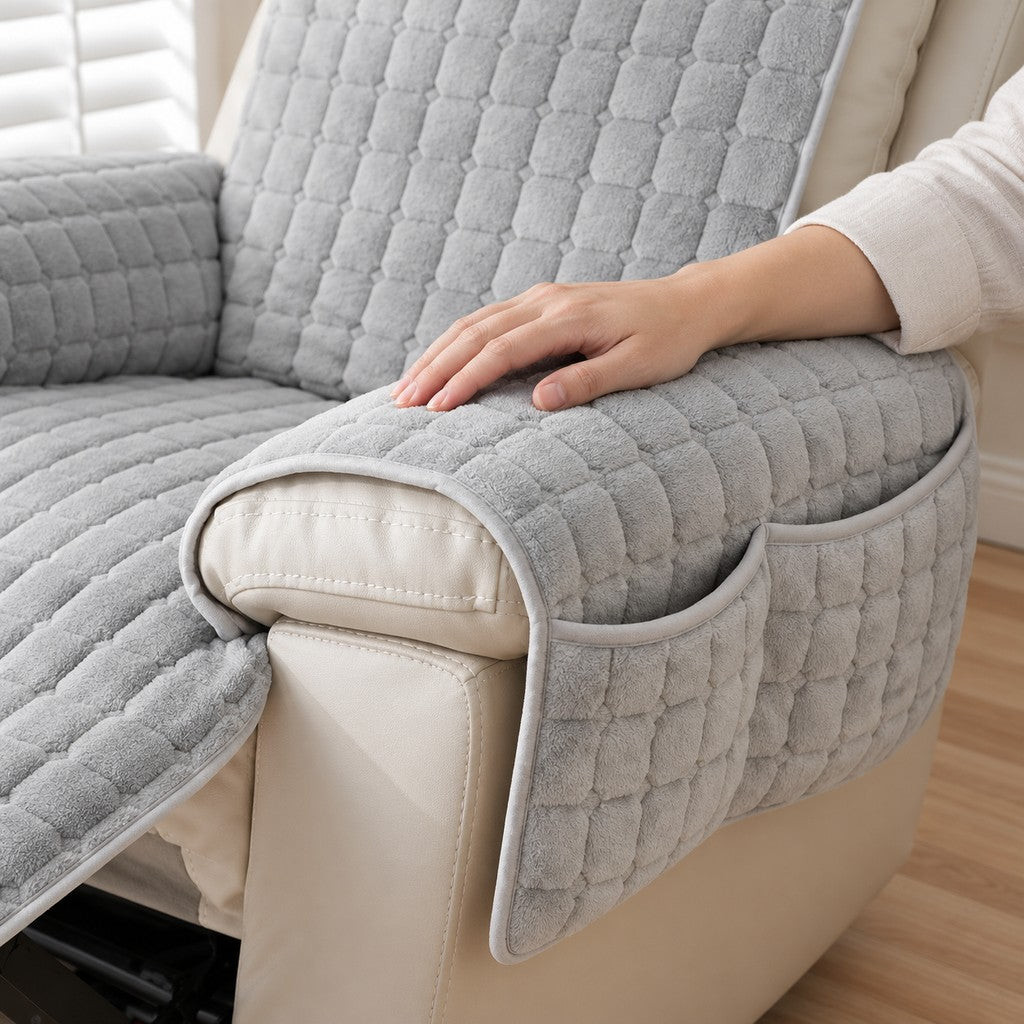 Hand resting on the raised square quilting of the light grey plush throw