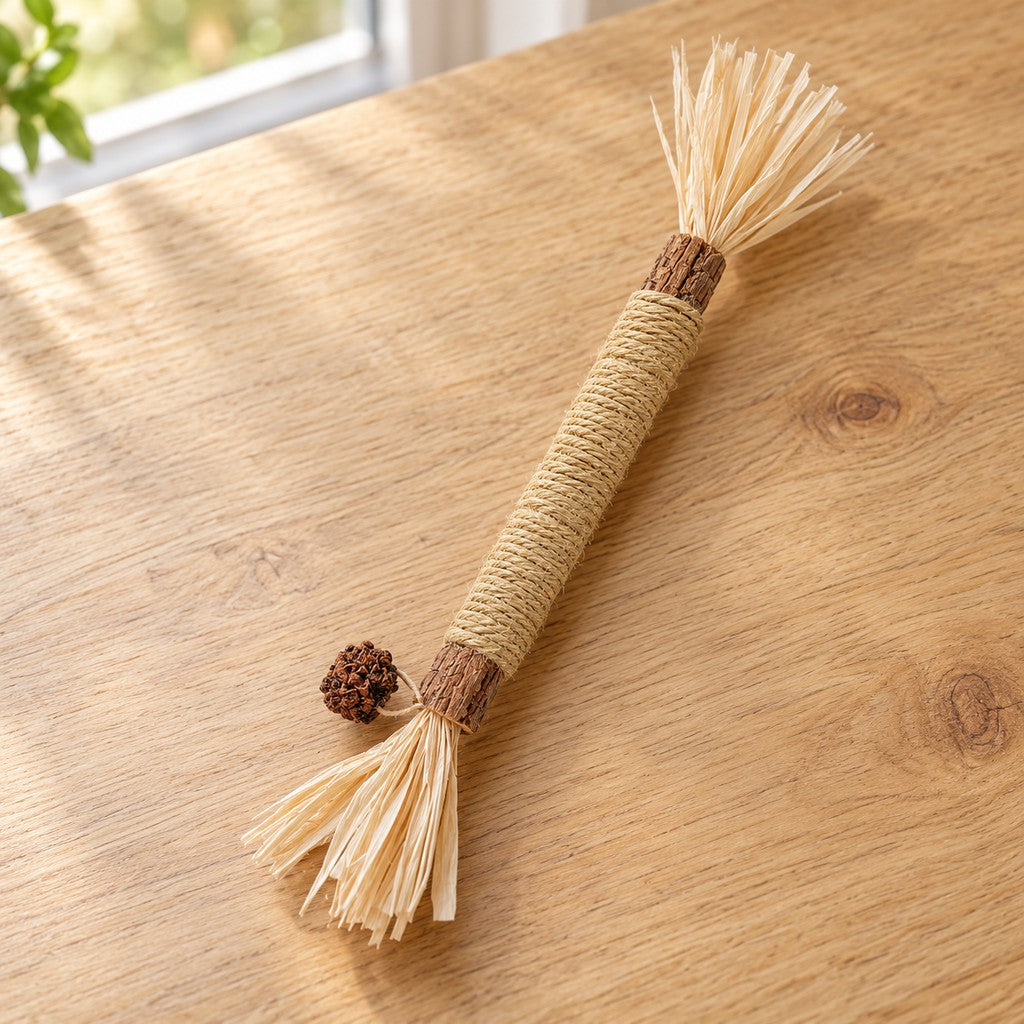 Whole stick on oak surface, raffia tufts at both ends