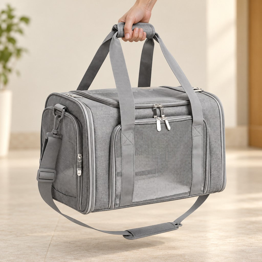 One hand lifting the grey carrier bag by its padded top handle grip