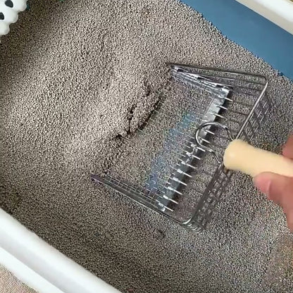 Hand pressing the mesh litter scoop into grey litter in a white tray