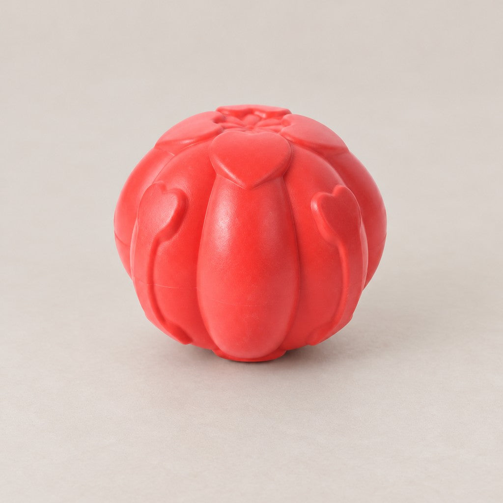 Red moulded dog ball with raised heart-shaped ribs and a petal pattern on top
