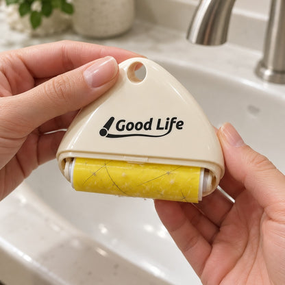 Hands holding the cream roller over a basin, yellow sticky roll visible
