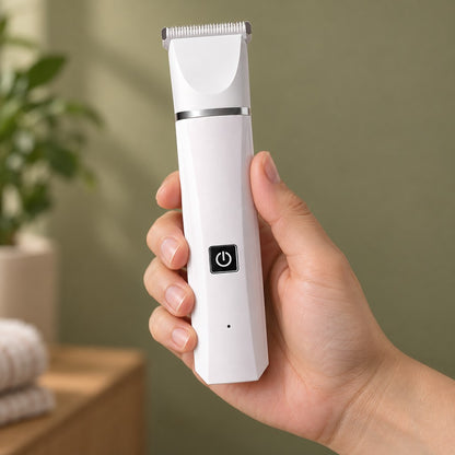 Hand holding the white trimmer upright, black power button facing the viewer