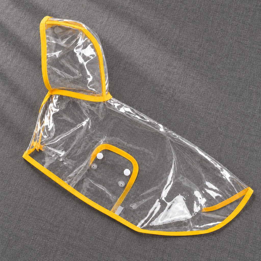 Empty clear rain cape with yellow edging laid flat on grey, showing hood and snap flap
