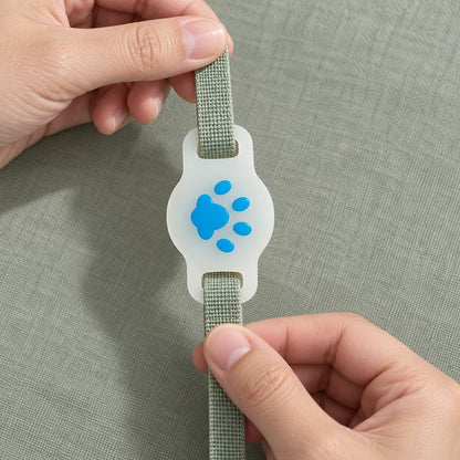 Hands threading a flat strap through the two slots of the paw holder