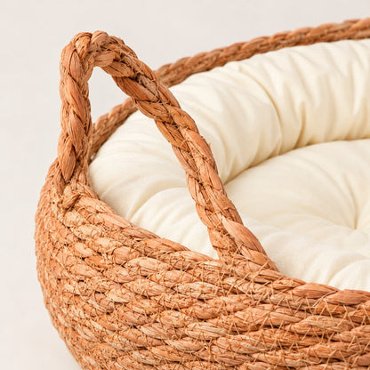 Close-up of a braided looped handle and woven rim above the cream bolster