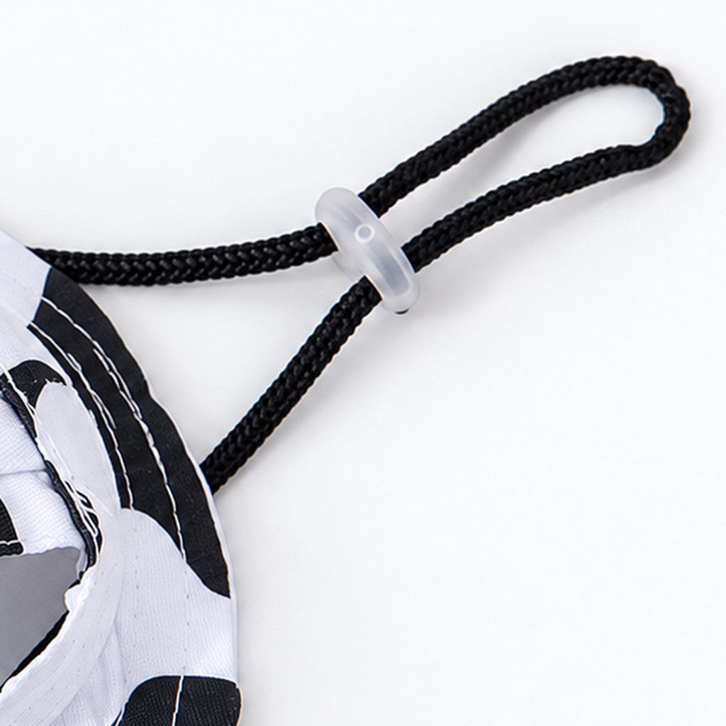 Close-up of black braided cord with clear toggle beside the cow-print hat brim