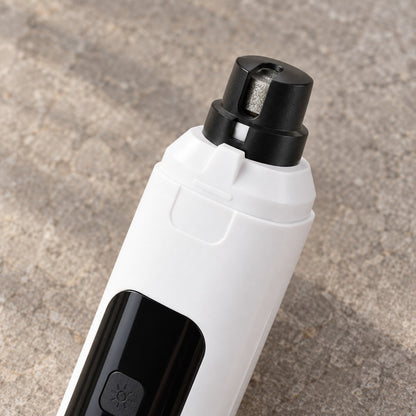 Close-up of the grinding head under the black cap and the lamp button